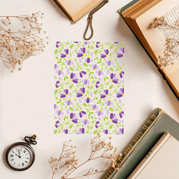 Floral notebook with dried flowers and books on a light surface