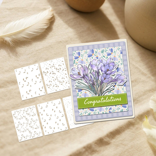 Greeting card with purple crocus design and 'Congratulations' text on a beige surface with decorative elements.