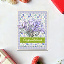 Greeting card with purple flowers and 'Congratulations' text on a white surface.