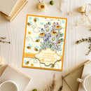 Decorative poster with flowers and bees on a wooden surface with books and flowers.