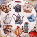 Collection of various teapots and a rabbit figure on a decorative plate.