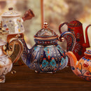 Decorative ceramic teapots with intricate designs on a wooden surface.