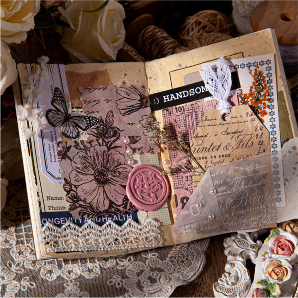 Decorative open book with vintage-style elements on a lace tablecloth.