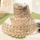 Spool of beige lace ribbon on a white surface with a blurred background
