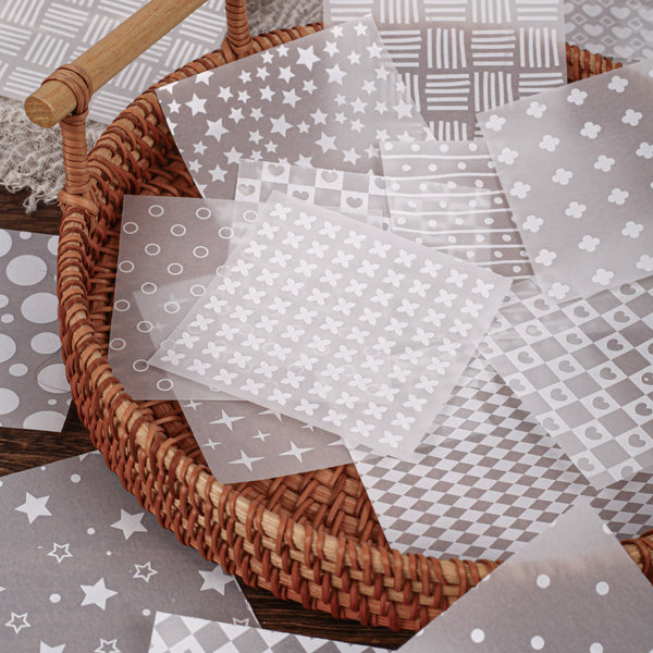 Wicker basket with patterned gray paper sheets on a wooden surface