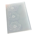 A rectangular translucent plastic mold or stamp with three embossed white floral designs, shown on a plain white background.