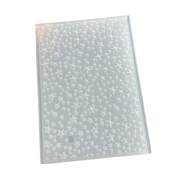 A clear plastic sheet covered with a dense pattern of small white star and starburst motifs, photographed on a plain white background.
