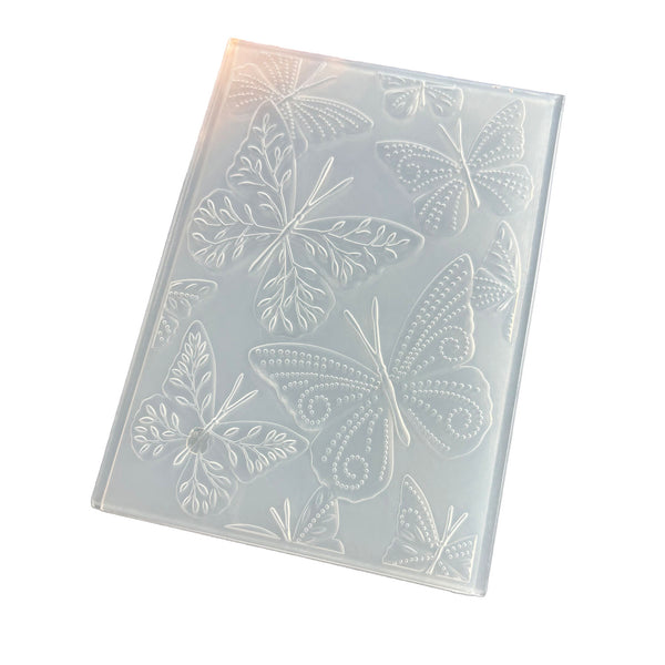 A translucent silicone mold with embossed butterfly and leaf patterns, shown at an angle on a white background.