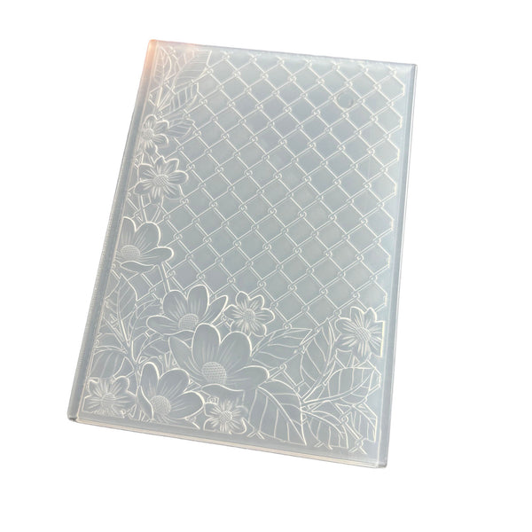 A clear plastic notebook cover with an embossed diamond lattice pattern and floral motifs along the bottom and left edges, shown on a plain white background.
