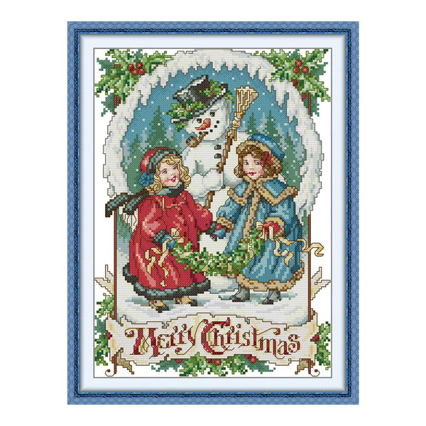 Cross-stitched design of two children with a snowman and 'Merry Christmas' text, framed with decorative elements.