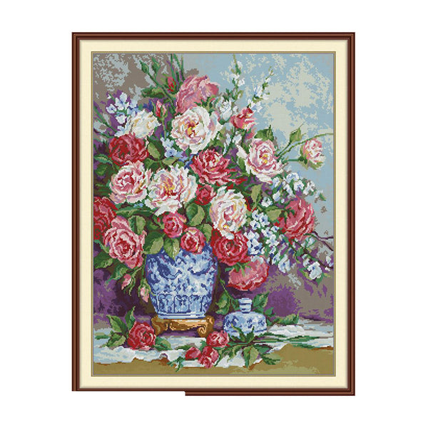 Framed artwork of a floral arrangement with a blue vase on a white background