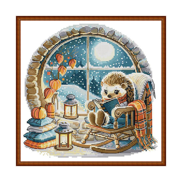 Hedgehog reading a book by a window with pumpkins and lanterns, framed artwork.