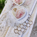 Decorative item with heart-shaped floral design and honeycomb pattern on a textured surface.