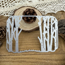 Metal tree-shaped cutting die on a wooden surface with decorative elements