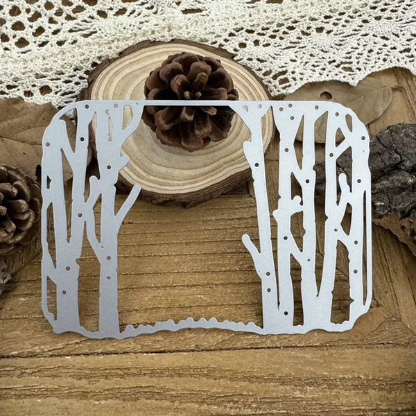 Metal tree-shaped cutting die on a wooden surface with decorative elements