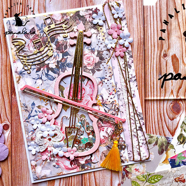 Decorative paper with musical notes, flowers, and tassels on a wooden surface.