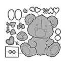 Gray teddy bear with various decorative elements on a white background