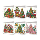 Six Christmas-themed diamond painting canvas sets arranged in a 2x3 grid on a white background. The designs include a decorated Christmas tree with gifts, a cozy fireplace scene, a large Christmas tree with a street lamp, a snowy house with Santa, a gold and silver Christmas tree, and a pink Christmas tree with presents.