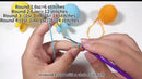 Close-up of hands crocheting with yarn and a crochet hook on a white background.