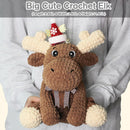 Crocheted elk toy with a Santa hat held by a person wearing a gray sweater.