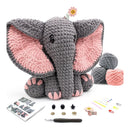 Crocheted elephant toy with yarn balls, a pattern sheet, and crochet tools on a white background