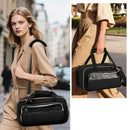 Woman holding a black handbag with a reflective silver stripe in an urban setting