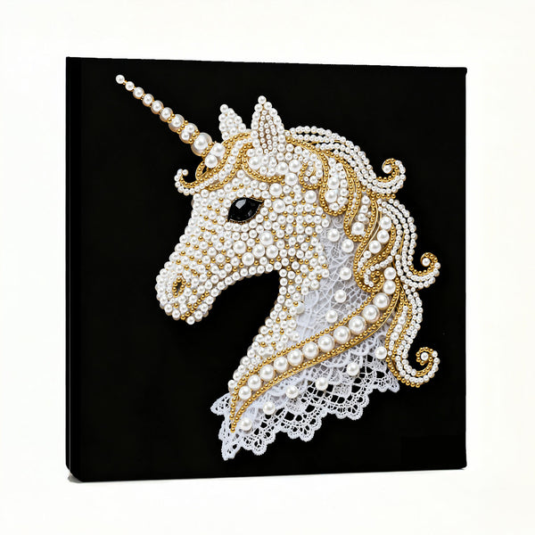 Decorative unicorn head with pearls and gold accents on a black background