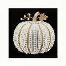Decorative pumpkin made of pearls and gold accents on a black background