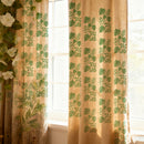 Sheer curtain with green leaf pattern in front of a window