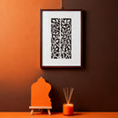 Framed artwork on a wall with an orange and brown gradient, featuring a small easel and candle.