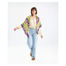 Woman wearing a colorful poncho and light blue jeans on a white background