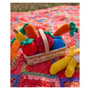 Colorful crocheted fruits and vegetables in a basket on a textured blanket