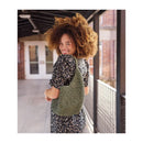 Woman wearing a green knitted vest on a balcony