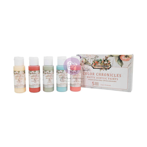 A set of five small bottles of Fabrique Art Color Chronicles matte acrylic paints lined up next to their decorative product box on a white background.