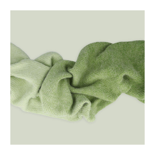 Green knitted fabric on a light beige background