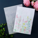 Transparent embossing folder with floral design on a dark background