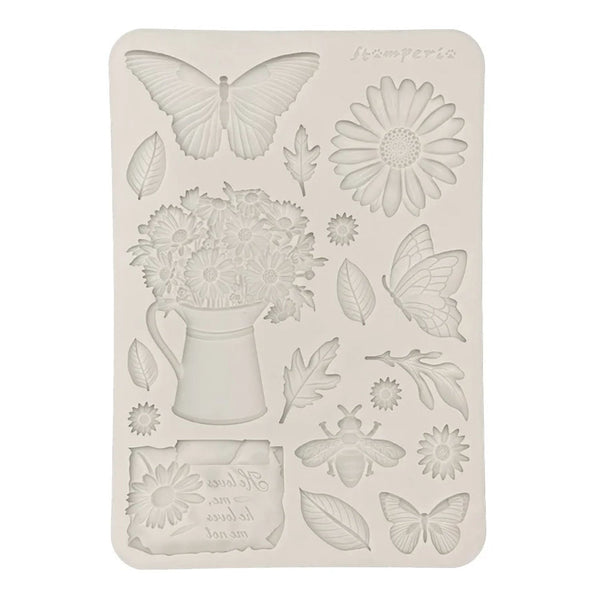 Decorative silicone mold with floral and butterfly designs on a white background