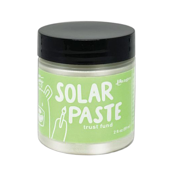 Jar of solar paste with a green label and black lid on a white background