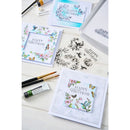 Set of birthday cards with floral and butterfly designs on a wooden surface.