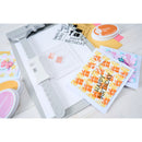 Colorful 'Happy Birthday' greeting cards with stamping tools on a white surface