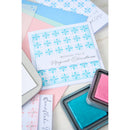 Christmas card with blue snowflakes and 'Wishing you a Magical Christmas' text, surrounded by ink pads.