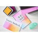 Colorful embossing folders and 'You're Invited' card on a white surface
