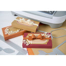 Card-making supplies including cut-out cards with bows and decorative elements on a white surface.