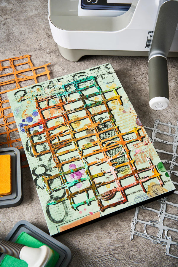 Artistic paper with geometric patterns on a wooden surface with crafting tools.
