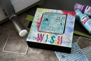 Colorful art project with 'WISH' text on a table with crafting supplies.