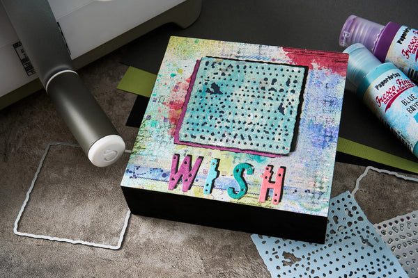Colorful art project with 'WISH' text on a table with crafting supplies.