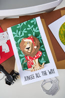 Card with a lion wearing a Santa hat and text 'Jungle All The Way' on a green background.