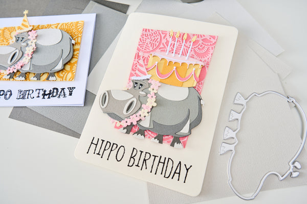 Hippo-themed birthday card with decorative elements on a gray surface