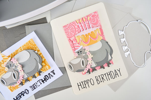 Two 'Hippo Birthday' greeting cards on a gray surface