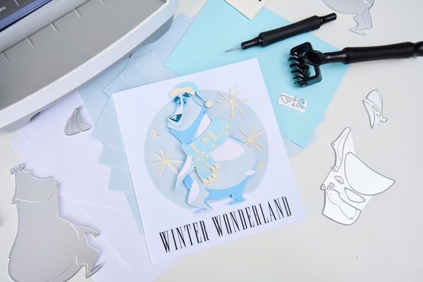 Card with 'Winter Wonderland' design and cut-out shapes on a table